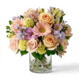 Pastel bouquet of roses, daisies, and alstroemeria in a clear glass vase