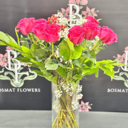 Pink roses arranged in a clear glass vase with baby's breath