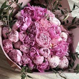 Pink peony bouquet wrapped in blush paper with greenery
