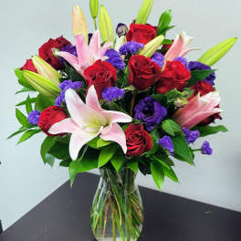 Bouquet of red roses and pink lilies in a glass vase