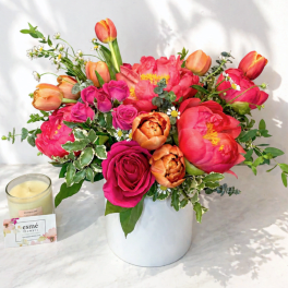 Bright mixed bouquet of pink and orange flowers in a white vase