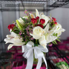 Bouquet of white lilies and red roses with a white ribbon