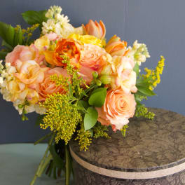 Peach and yellow bouquet of roses with white filler flowers