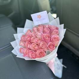 Bouquet of pink roses wrapped in white paper