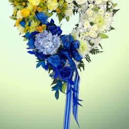 Heart-shaped bouquet of yellow, white, and blue flowers with a ribbon