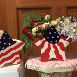 Star-shaped patriotic flower arrangements in painted ceramic containers