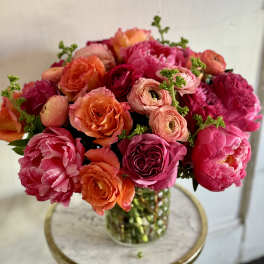 Bouquet of pink, orange, and red flowers in a glass vase