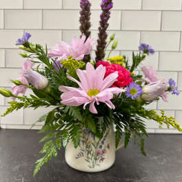 Mixed bouquet in a floral ceramic vase with pink and purple blooms
