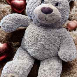 Gray plush teddy bear with metallic heart decorations