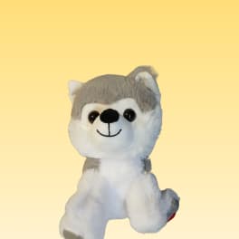 Gray and white plush husky toy on a plain yellow background