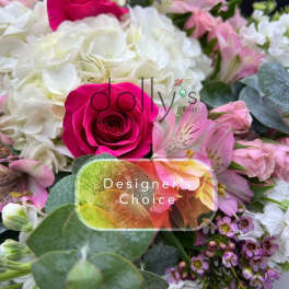 Bright arrangement with hot pink roses, white hydrangeas, and assorted pink flowers.