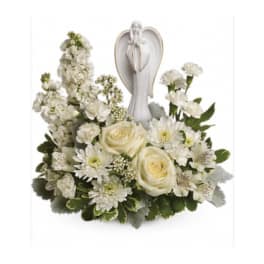 White floral arrangement with roses and daisies beneath an angel figurine
