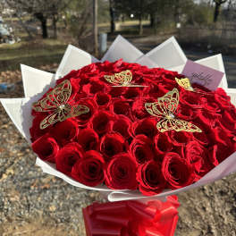 Bouquet of red roses wrapped in black paper with a black ribbon
