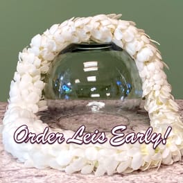 White floral garland draped around a clear glass bowl on a tabletop