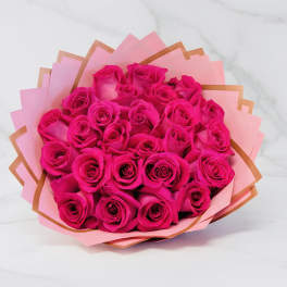 Bouquet of bright hot pink roses wrapped in layered pink and peach paper
