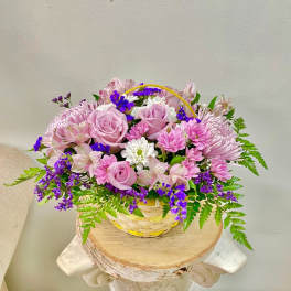 Pink and purple flower basket with roses and daisies