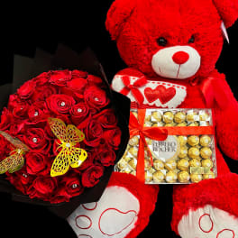 Red rose bouquet with large red teddy bear and Ferrero Rocher chocolates on a black background