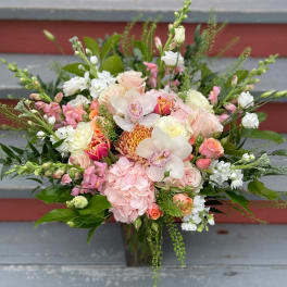 Mixed bouquet of pink, white, and peach flowers with orchids and roses