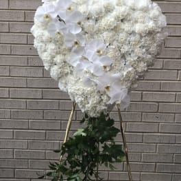 Heart-shaped white floral standing spray with orchids and greenery