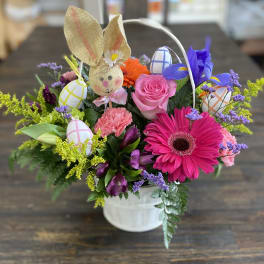 Spring bouquet in a white bucket with a bunny and painted eggs