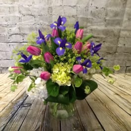 Bouquet of purple irises and pink tulips in a glass vase
