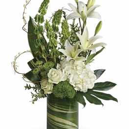 White lilies and roses in a green glass vase