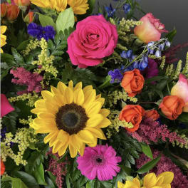 Mixed bouquet with sunflowers, roses, and a pink gerbera daisy