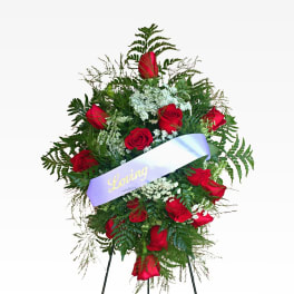 Standing spray of red roses with a lavender ribbon