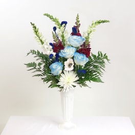 Blue and white flowers arranged in a tall white vase