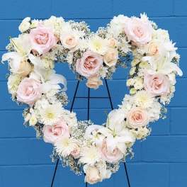 Heart-shaped floral wreath with pink and white roses and lilies