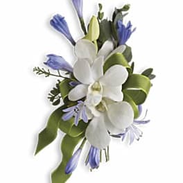 White orchid and light purple flower corsage with green ribbon accents