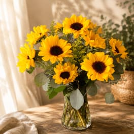 Bouquet of yellow sunflowers in a clear glass vase