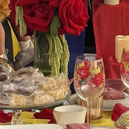 Red rose centerpiece in a glass vase on a decorated table