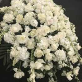 Large white floral spray with clustered blooms on a dark background