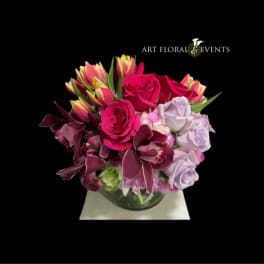 Pink and lavender rose arrangement in a glass vase