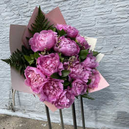 Bouquet of pink peonies wrapped in pastel paper
