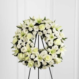 White floral wreath on a black stand