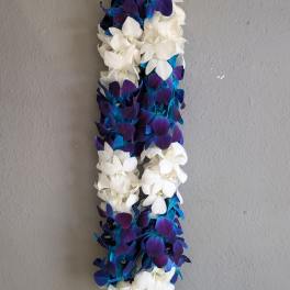A long floral lei made of white and blue-purple blossoms.