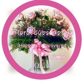 Pink rose bouquet in a glass vase with a ribbon