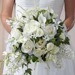 Bride holding a white bouquet of roses and calla lilies