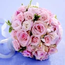Round bouquet of pale pink roses with a white ribbon