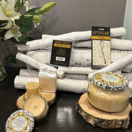 Candles and fragrance products arranged with a white lily stem