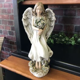 Angel figurine holding a small bouquet of white flowers