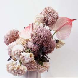 Pink and cream floral arrangement in a pale vase