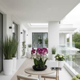 Orchid arrangement in a black bowl on a patio table