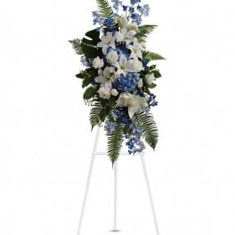 White and blue floral standing spray on a white easel