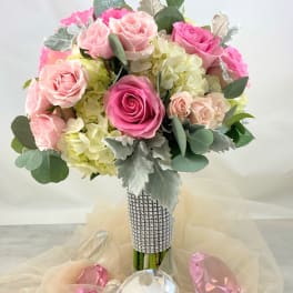 Pink and blush roses arranged in a jeweled bouquet with pale hydrangeas