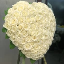 Large heart-shaped bouquet of white roses on a stand