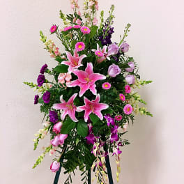 Tall standing floral spray with pink lilies, roses, and purple orchids