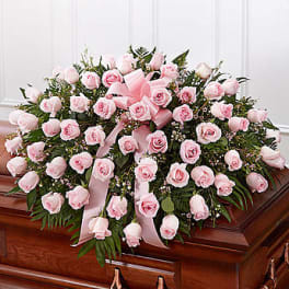 Pink rose casket spray with ribbon accents